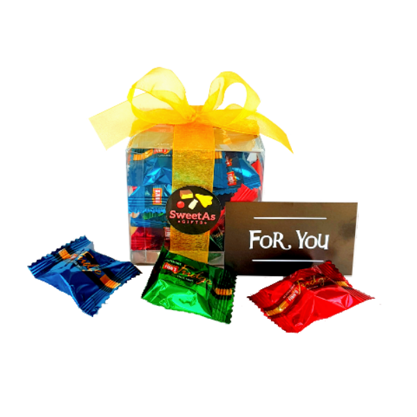 Brightly coloured individual pieces of fudge inside a gift box with ribbon
